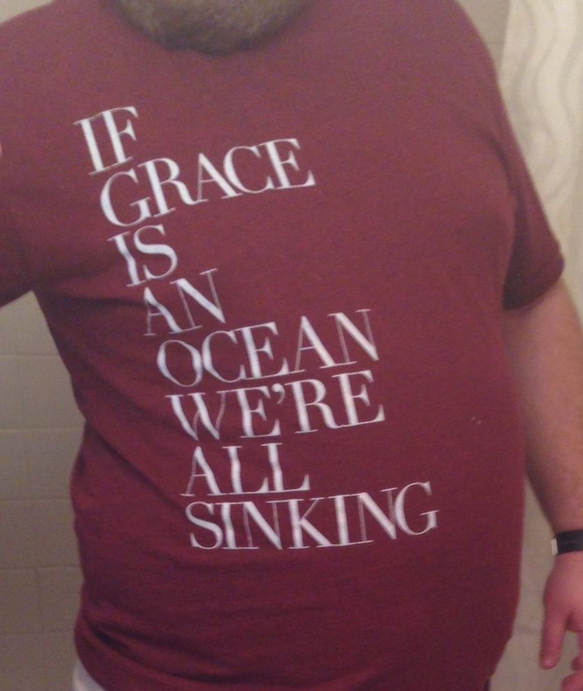 Photo of a maroon shirt with 'If Grace Is An Ocean We're All Sinking' printed on it.