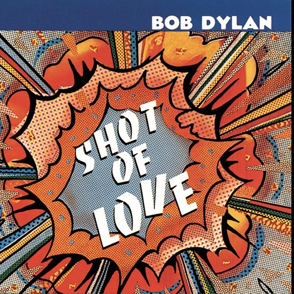 Album Art of Bob Dylan's Shot Of Love album - A close up drawing of a big, cartoon-style explosion, with orange light and lines going out from the center. In the center is printed the album title in large, white text. Across the top is a deep blue background and the artist's name is off to the right in white text.
