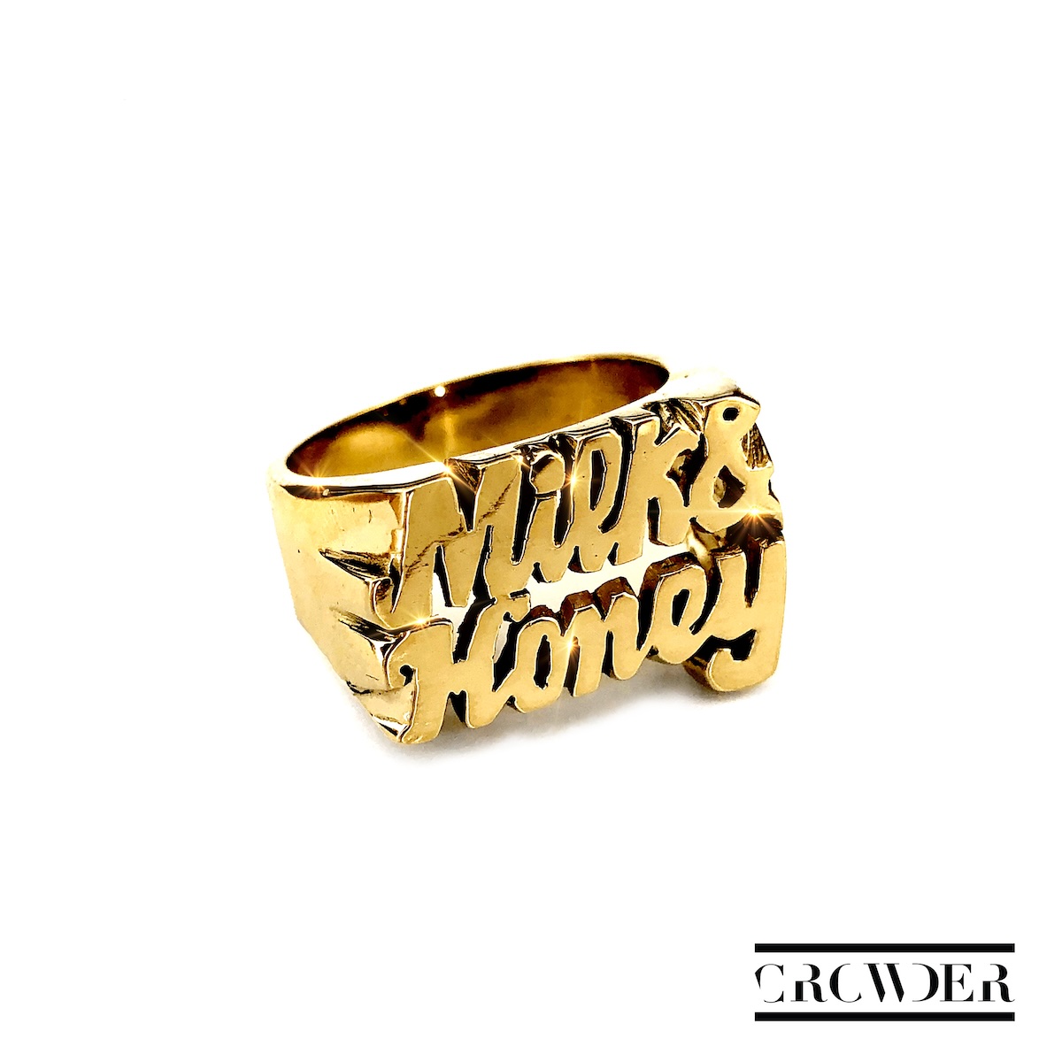 Album Art of Crowder's Milk And Honey album - On a white background, in the middle is a gold ring that has 'Milk and Honey' etched into the top of the ring. In the bottom right, there are two black bars with a 'Crowder' word mark between them, in all caps with some of the vertical bits of letters missing.