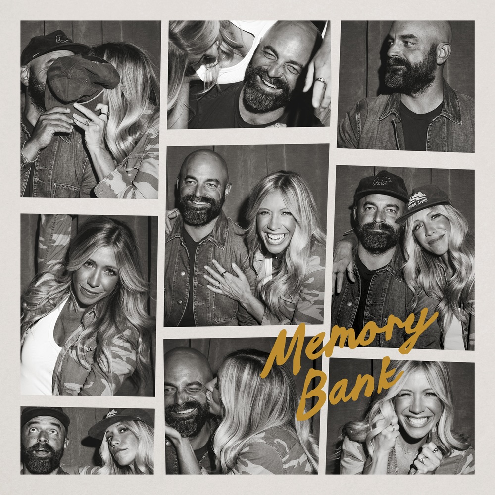 Album Art of Drew and Ellie Holcomb's Memory Bank album - On a beige background, a set of 9 black-and-white photos of a white man and a white woman. The man is bald, has a black beard and mustache cut fairly short, and in some photos is wearing a baseball cap. The woman has long, light-colored hair and in a few photos has a baseball cap on as well. Above the photos in the bottom right, the album title is printed in a gold color in a font that looks somewhat hand-written.