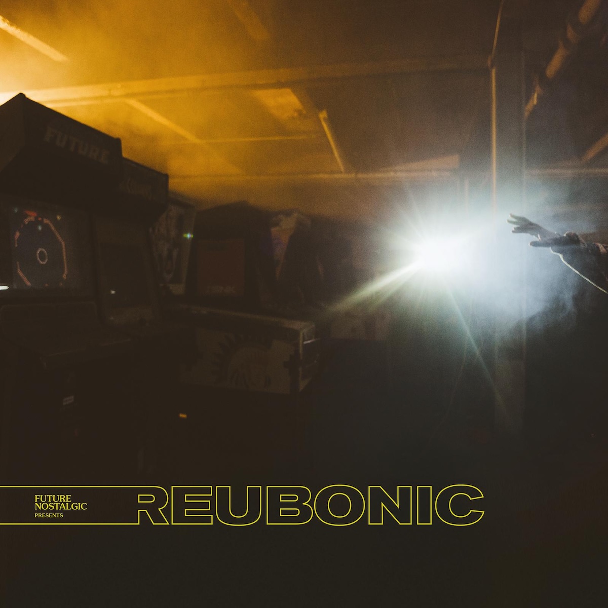 Album Art of John Reuben's Reubonic album - A photo that seems to be a large, low-ceilinged room with turned off pinball machines and arcade cabinets to the left in the dark, though there's an orange glow coming from above and behind them. On the right, a bright white light is overpowering everything else, except to the far right, one hand is in front of the light reaching out. In the blackness at the bottom is printed the album title in a yellow outline. The left part of the 'R' extends all the way to the left, with the words 'Future Nostalgic Presents' inside it.
