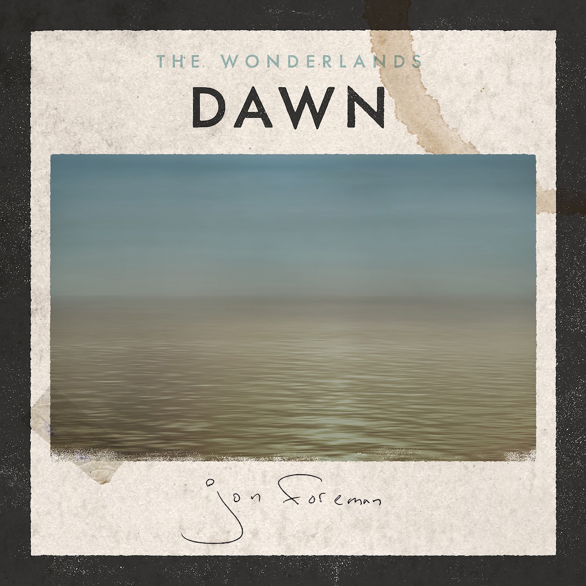  Dawn EP - On what looks like rough, light brown paper with a coffee cup stain in the top right, there is a photo of a light blue sky with a with some potential clouds over a somewhat calm, wide body of light brown water. On the bottom edge, the image is worn out a bit, and there's a piece of clear tape on the bottom left of the image, affixing it to the paper. Above it, in the middle, it says 'The Wonderlands' in a smaller, light gray font, and 'Dawn' in a much larger black text. Below the photo, there's a handwritten, thin pen signature of Jon Foreman. There's also a thick black border around it.