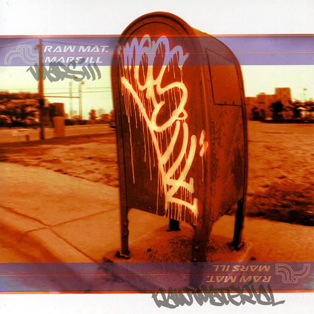 Album Art of Mars ILL's Raw Material album - A heavily red-tinted, wide-angle photo of a mailbox on the side of a street. The mailbox fills most of the area, and printed on the biggest side is spray paint that says the group name. Across both the top and bottom it has a blue, semi-transparent line with red borders that kinda looks like a US Postal Service logo, and it has group's 'M' logo and their name printed there, also with a the words 'Raw Mat.' printed as well. Behind the mailbox can be seen an empty field and light poles and buildings from a city.
