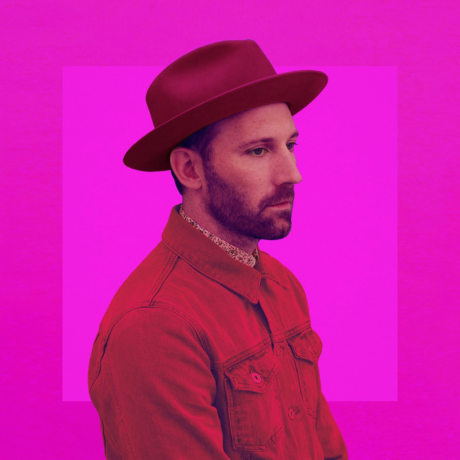 Album Art of Mat Kearney's Crazytalk album - Mat Kearney, a white man with a short beard and moustache, in a red denim shirt and red hat, looking off to the right. The background is neon pink with a slightly darker pink, wide border.