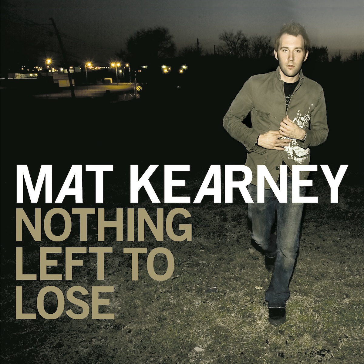 Album Art of Mat Kearney's Nothing Left To Lose album - A color photo of a man moving toward the camera in a the middle of a dark field at night. There's some sort of light from behind the camera illuminating him and the ground of short, maybe brown-ish grass around him. But besides that, it's mostly black except for the sky is a bit more grey than the black ground that touches the skyline. In the top left, a parking lot with lights can be seen off in the distance. Printed above the photo in large letters across the middle in white is the artist's name, with the album title below it on three lines in alight brown color.
