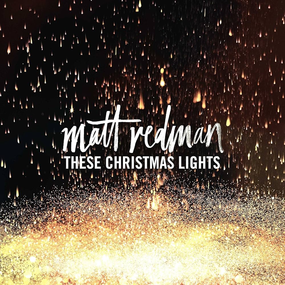 Album Art of Matt Redman's These Christmas Lights album - A photo of what looks like small balls of fire dropping from a black sky in a large group, with a glow of smaller sparks near the bottom until the bottom is pretty much all a gold white of burning light. Printed above that is the artist name in a flowing white script-like font, with the album title in white, all-caps, block letters below the name in the center.