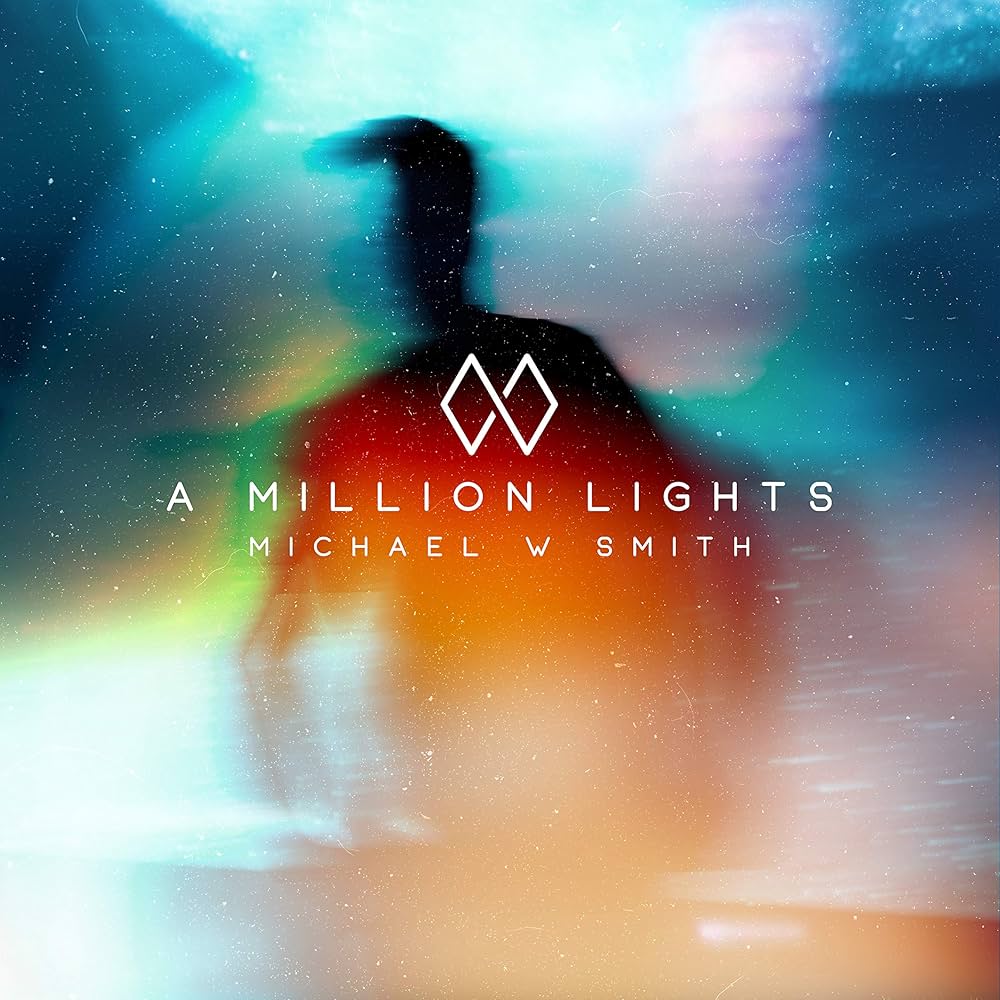 Album Art of Michael W. Smith's A Million Lights album - In a swirl of color, a silhouette of a man is in the center but it's a bit blurry. The swirl of colors seems to also be overlaid with a lot of stars throughout. The words 'A Million Lights' are in white in the center, as well as the artist's name and an 'MW' logo below and above.