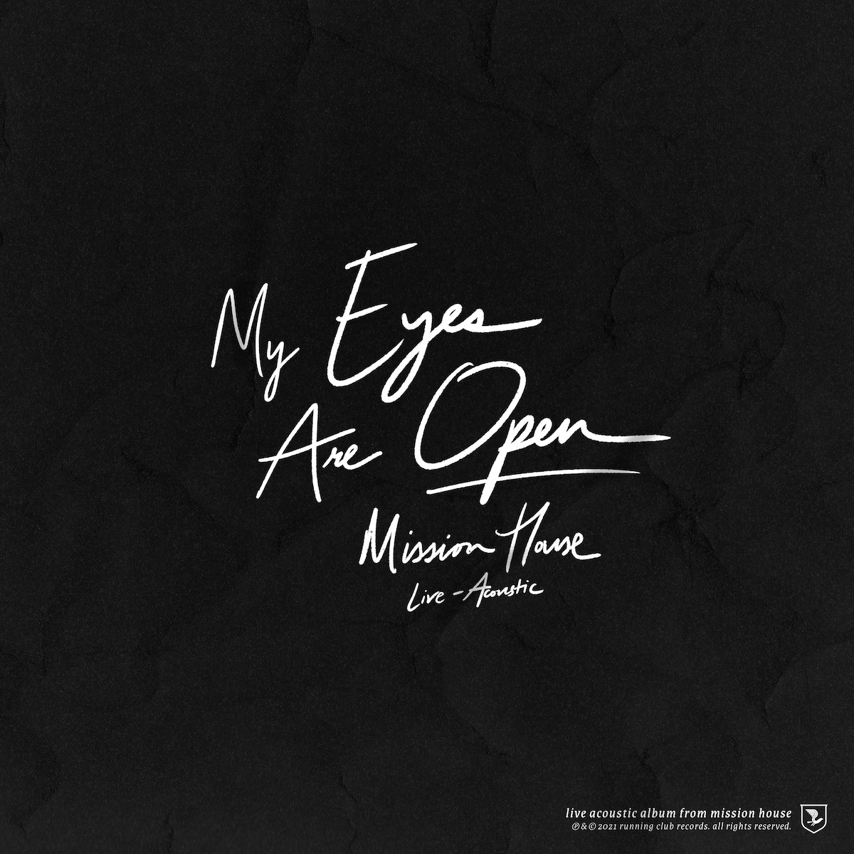 Album Art of Mission House's My Eyes Are Open album - On a solid black background, written in white in a marker-like handwriting font is the album title in large text, with the band name in smaller text. Even smaller below that is the words 'Live - Acoustic' as well. In the bottom right is the Running Club Records shield with a bird logo, and a very small copyright text and the words 'live acoustic album from mission house' in an italics serif font.
