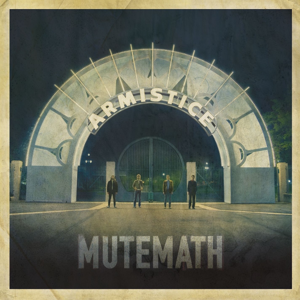 Album Art of Mutemath's Armistice album - A photo of four people on a dark night standing in front of a gate, shot from fairly far back. They are standing 2-3 feet away from each other in a line in front of the gate, and the gate has a large circular arch with a geometric design in mostly white and green on it. The arch also seems to have lights on it and the arch and the ground in front of it is well-lit. On the arch is the album title in white lights, it looks like, and the band's name is in the shadows at the foreground of the bottom of the picture. Around the edges is a border that looks like yellowed, worn paper.