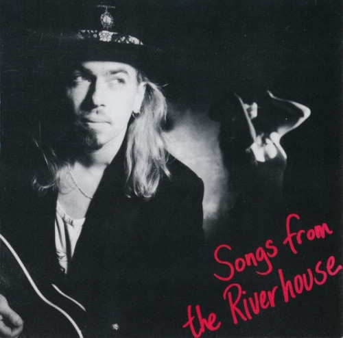 Album Art of Robert Vaughn and The Shadows's Songs From The Riverhouse album - The original 1991 CD cover artwork, a black-and-white photo of a young man with long, blonde hair on the left who is wearing a black jacket, black hat, and is playing an acoustic guitar. On the right, in the distance can be seen a woman in a cocktail dress with her face obscured mostly in shadow and her arms on each side of her head. In the bottom right, written askew in red ink is the album title.
