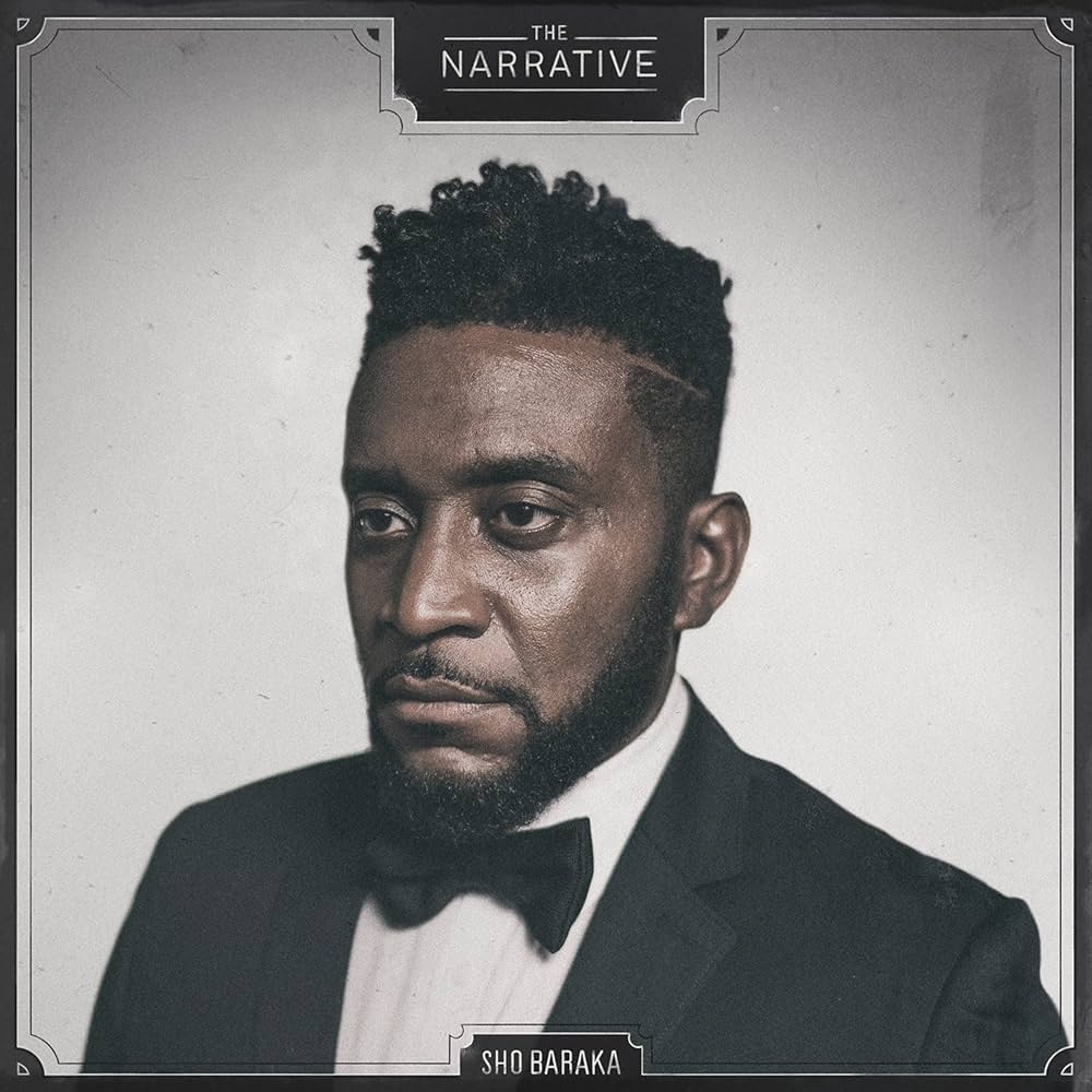 Album Art of Sho Baraka's The Narrative album - On a grey background, a photo of a black man with longer, curly hair on the top and very short hair on the face and sides, looking to the left of the camera with a neutral face, not smiling nor frowning. The man is wearing a black suit with a white shirt and black bow tie. Around the edge is a black border with some extra flourishes around the corners, and indents at the top and bottom in the center. On the top, the black indent has the album name in larger letters, while the bottom has the artist name in smaller letters.