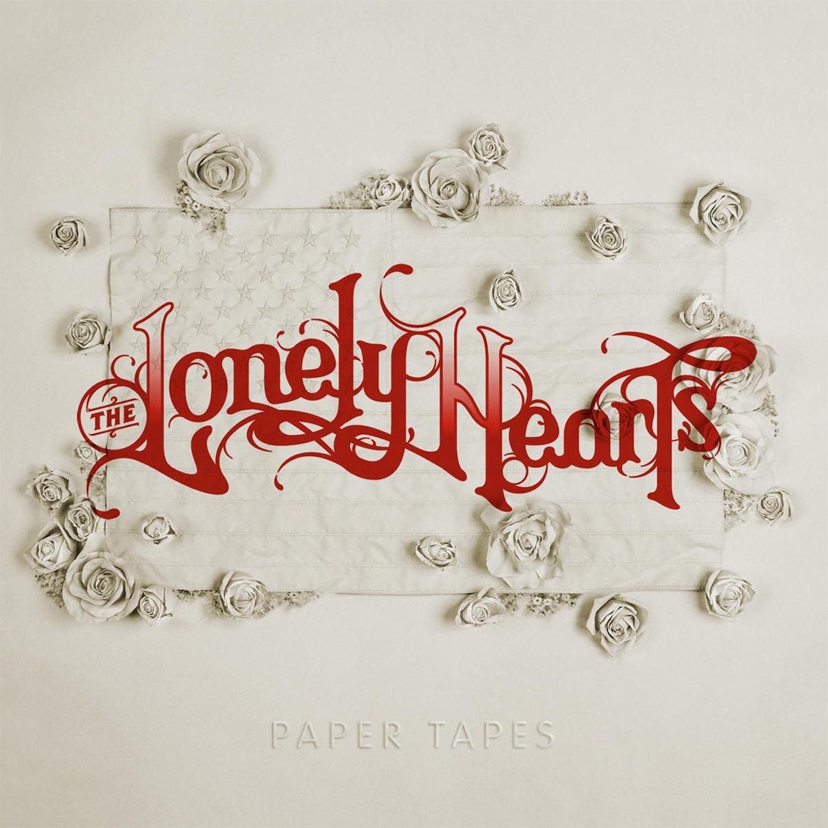 Album Art of The Lonely Hearts's Paper Tapes album - A photo of a white piece of paper, and attached to the paper in the middle ia an embossed white paper American flag, with small roses and other flowers covering parts of the flag. Actually, maybe it's not all made of paper, but is made of something else and just all painted that same off-white color as the paper. Over the top of this is printed in red the band name in very large, decorative red text. And at the bottom, embossed into the paper is the album title.