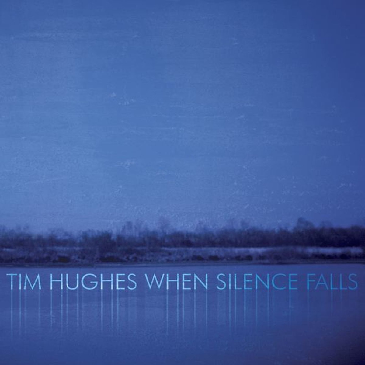 Album Art of Tim Hughes's When Silence Falls album - A very blue and simple photo. On the bottom quarter is blue water, and just above that an landscape of small bushes or trees on a hillside approaching the water. (It's hard to tell scale.) Above this, is a dark blue sky just about the same color as the water. The artist's name and the album title are printed on top of the water with a reflective effect making it look like it's sitting on top of the water.