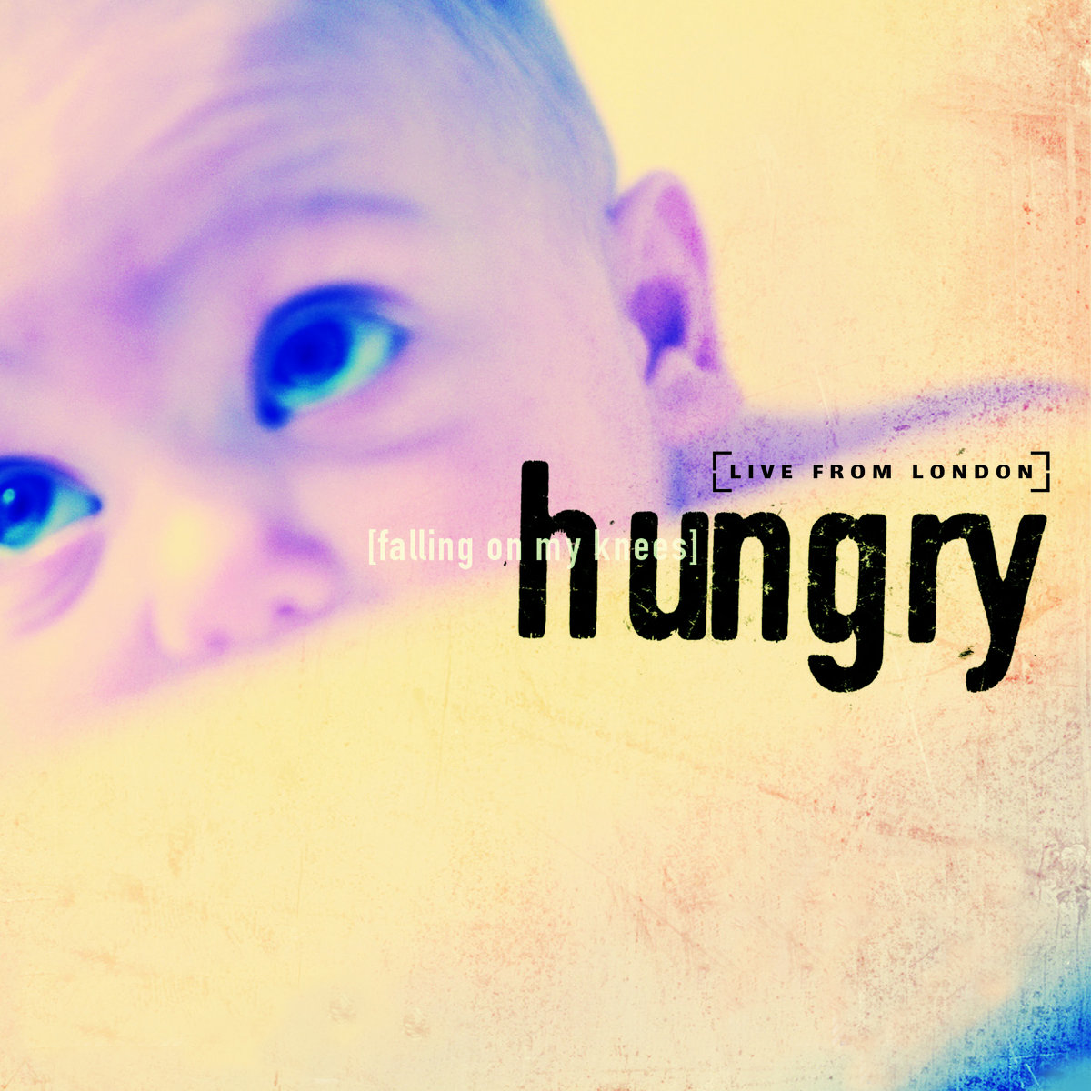 Album Art of Vineyard UK's Hungry album - A photo of a baby peeking up over some sort of barrier in front of them. Their big, blue eyes are looking far up. On top of it, 'Hungry' is written in blocky letters and then 'Falling on my knees' and 'Live from London' in much smaller letters.