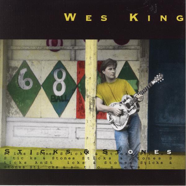 Album Art of Wes King's Sticks And Stones album - On a black background, across the middle form right to left is a photo of a man standing against a pole and holding a dobro guitar. The image looks like it's been de-saturated and re-colored, maybe, as his skin looks less pink, and the yellows and greens in the photo is highlighted, including his golden yellow shirt and the green diamonds painted on the wall behind him. In front of the bottom of the photo, a yellow floor, is printed the album title in larger text in black and white letters, and in much smaller black letters over and over. Above the photo in the black is the artist's name in large golden yellow text.